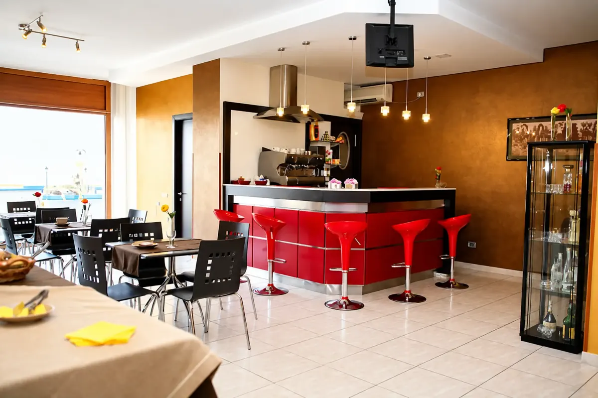 Bar del Tea Palace Hotel con bancone rosso e tavoli